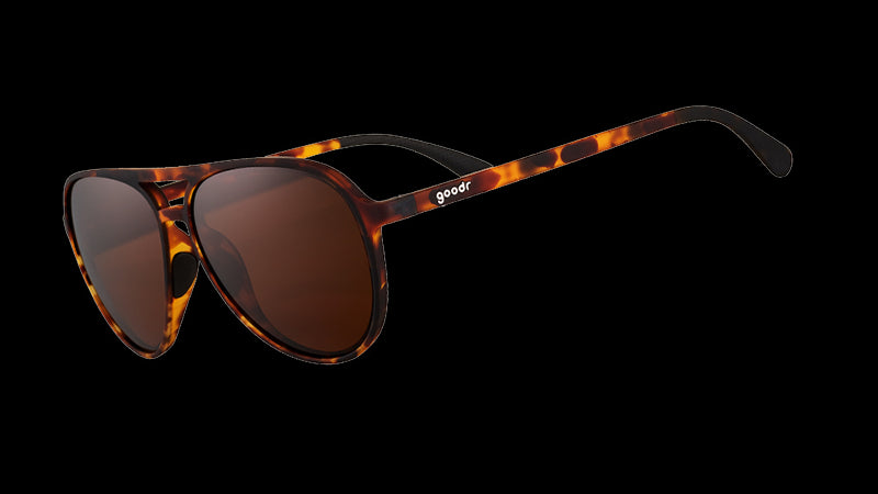 Dreiviertelansicht einer braunen Fliegersonnenbrille aus Schildpatt mit braunen, nicht reflektierenden Gläsern auf weißem Hintergrund.