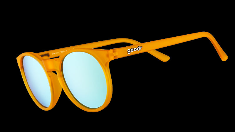 Dreiviertelansicht einer runden orangefarbenen Sonnenbrille mit hellblauen, reflektierenden, polarisierten Gläsern.