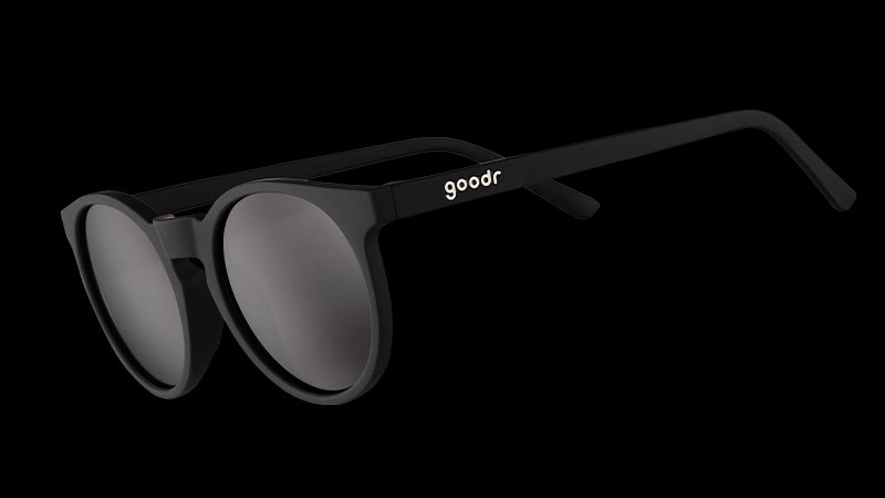 Dreiviertelansicht einer runden schwarzen Sonnenbrille im Retro-Stil mit nicht reflektierenden schwarzen Gläsern.