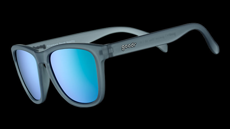 Dreiviertelansicht einer quadratischen Sonnenbrille mit grauem, durchscheinendem Rahmen und grünen, reflektierenden Gläsern.