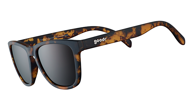 Dreiviertelansicht einer quadratischen braunen Schildpatt-Sonnenbrille mit braunen nicht reflektierenden Gläsern auf weißem Hintergrund. 